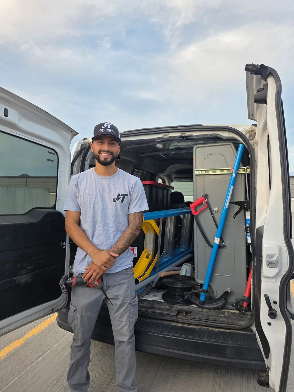 JT Electrical Solutions electrician beside a fully equipped work van