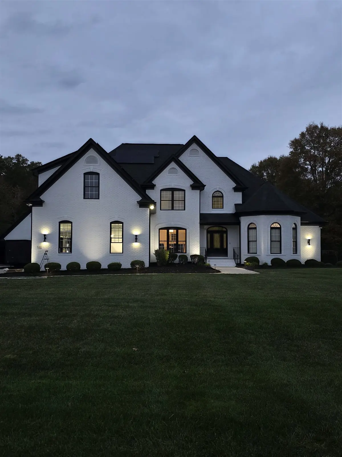 Completed custom home with exterior architectural lighting at dusk