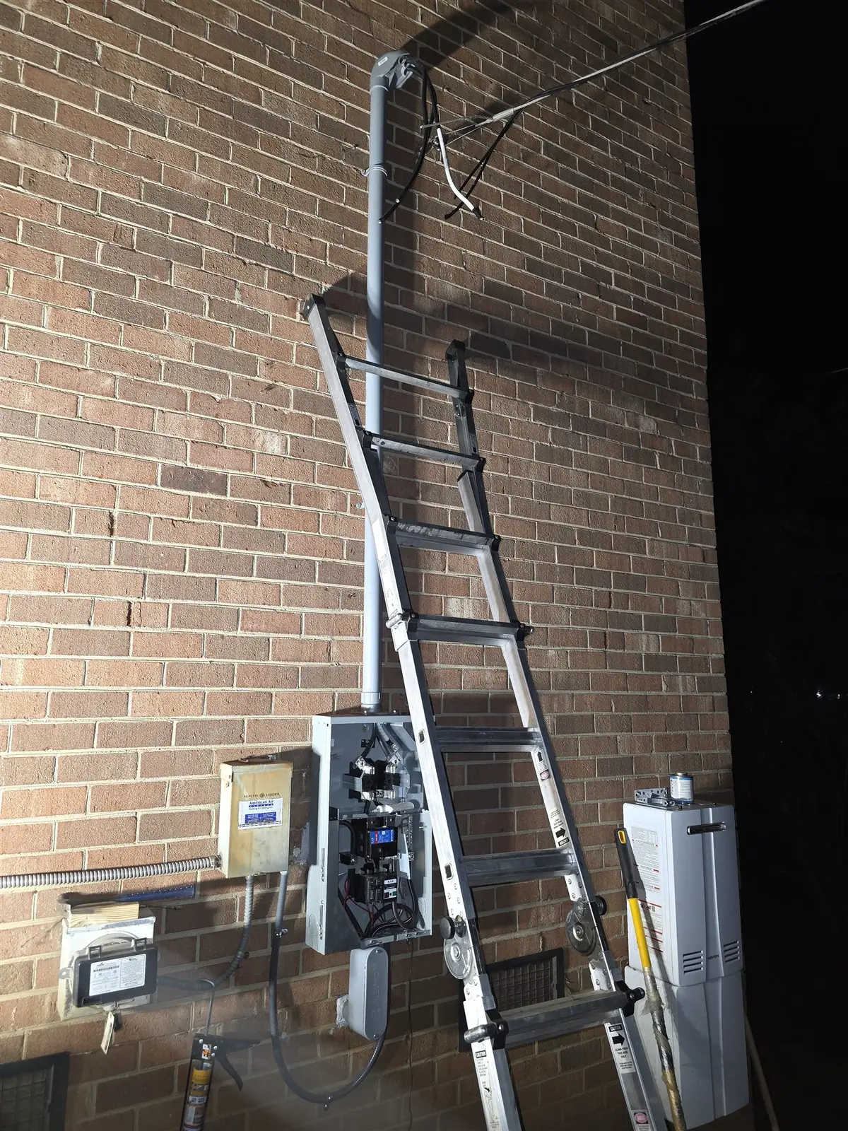 New exterior electrical service equipment during installation on a brick building
