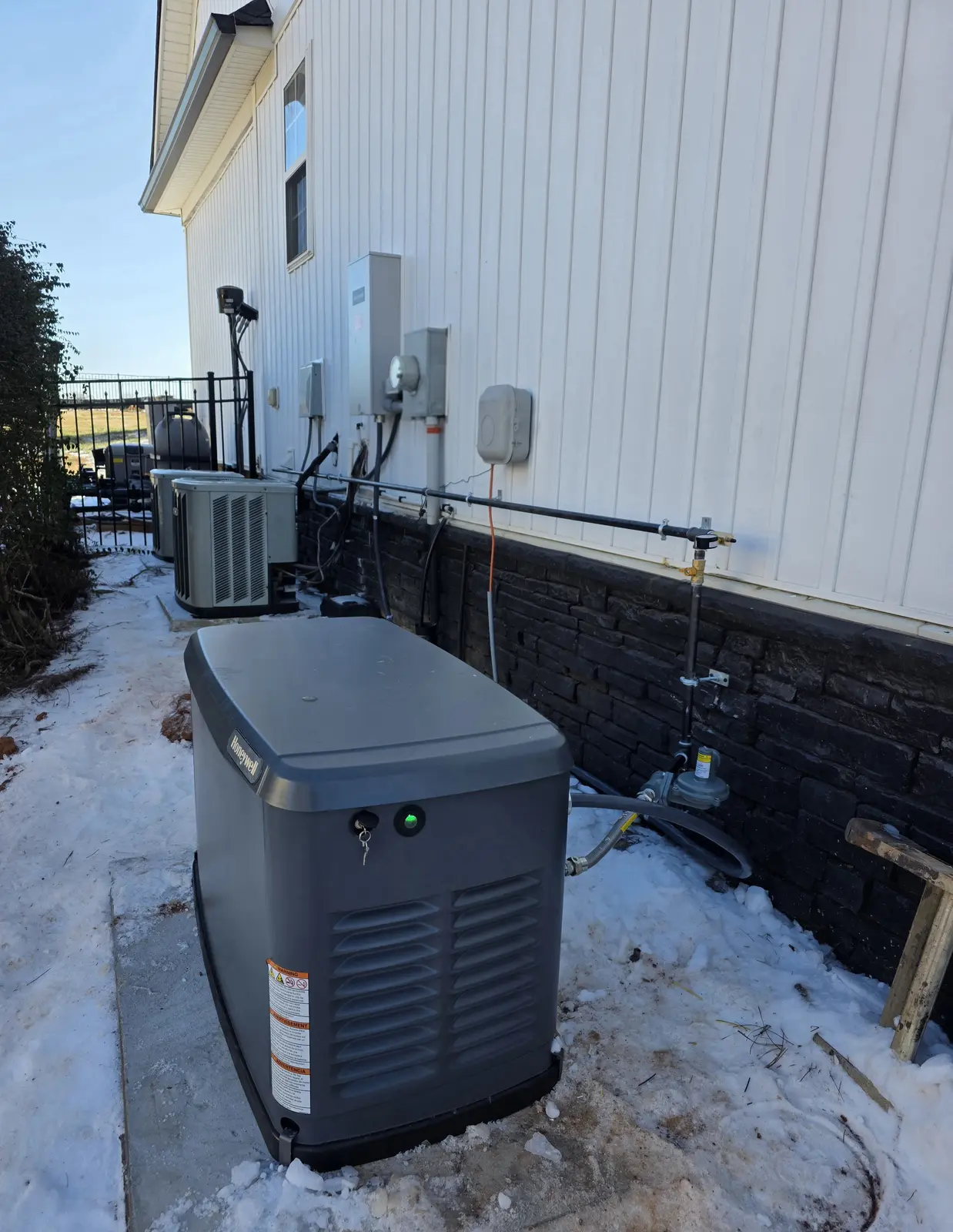 Completed standby generator installation beside a home